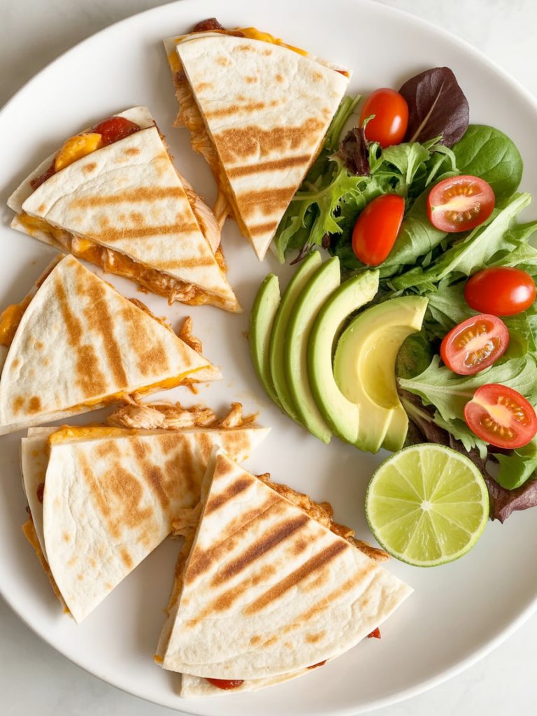 Quesadilla wedges on white plate with large fresh salad showing healthier serving option