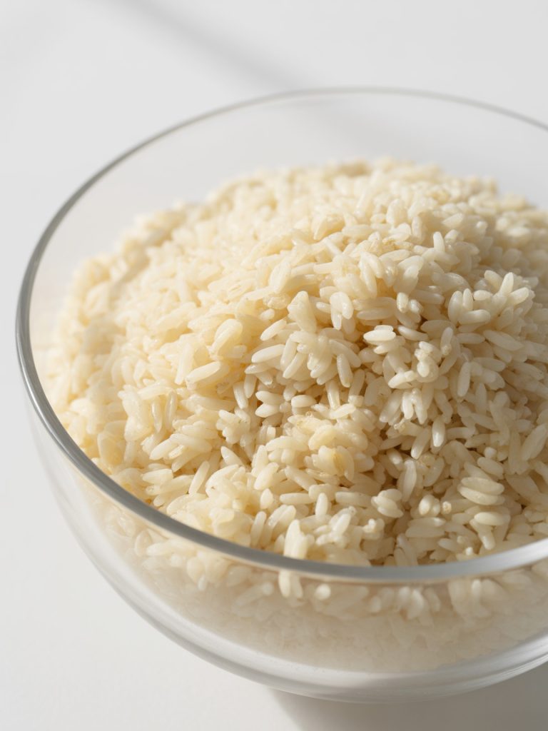 Close-up of day-old cold white rice in glass bowl showing separate dry grains ideal for fried rice