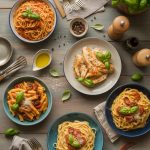 Assortment of easy pasta dinner recipes displayed on wooden table with various colorful sauces and fresh garnishes