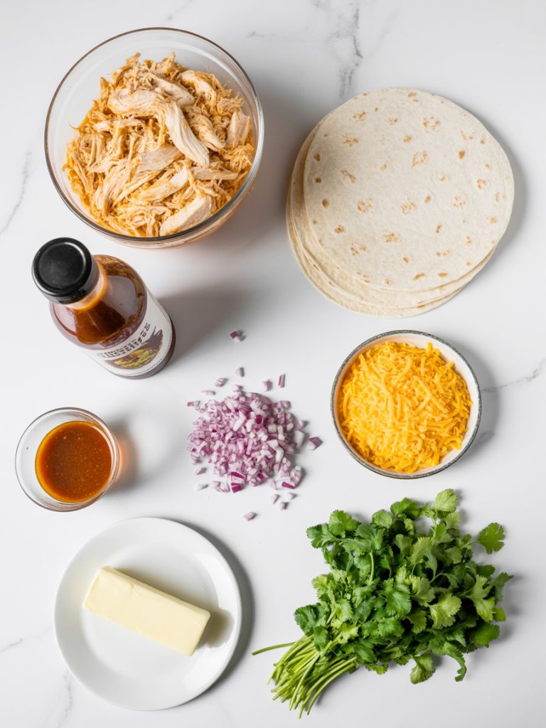 Organized flat lay of quesadilla ingredients including chicken, BBQ sauce, tortillas, cheese and cilantro on marble surface