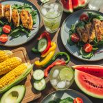 Colorful spread of summer dinner recipes including grilled chicken, fresh salads, and seasonal vegetables on a wooden table