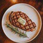 Perfectly cooked ribeye steak with herb butter on elegant plate - best steak recipes for dinner