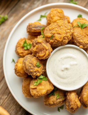 Crispy golden fried mushrooms with ranch dressing for dipping garnished with parsley
