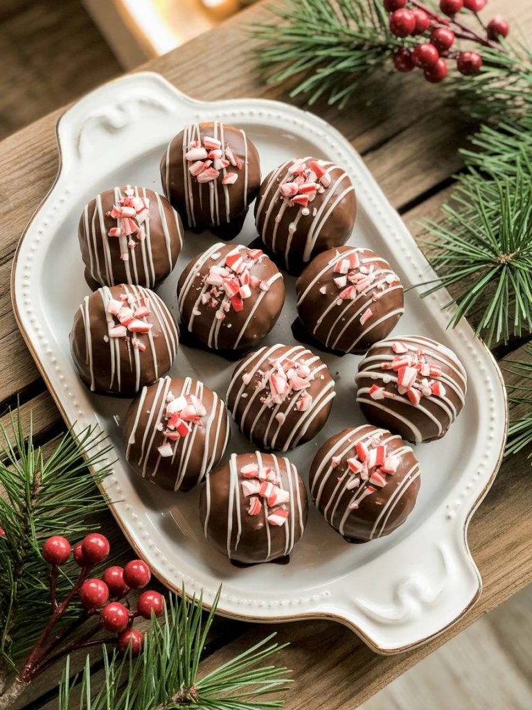 Chocolate-coated peppermint Oreo balls topped with crushed candy canes on festive holiday platter
