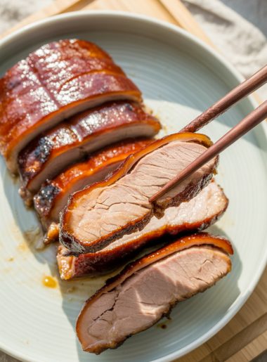 Chinese BBQ pork char siu with caramelized glaze on white plate