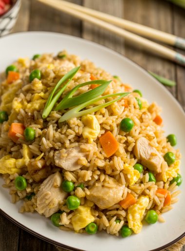 Chinese chicken fried rice on white plate with chicken and vegetables