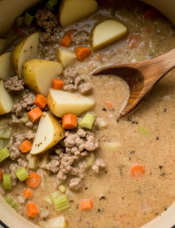 Pot of creamy potato hamburger soup with chunks of potatoes, ground beef, and vegetables in rich broth