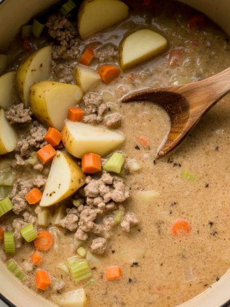 Pot of creamy potato hamburger soup with chunks of potatoes, ground beef, and vegetables in rich broth