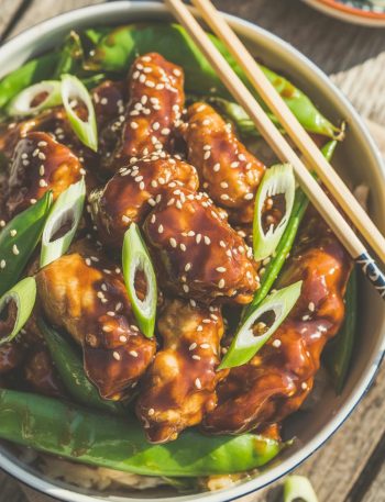 Easy General Tso's chicken with sesame seeds and green onions in bowl