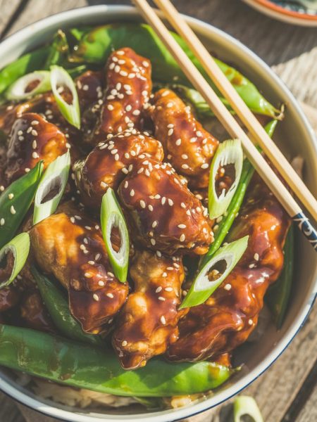 Easy General Tso's chicken with sesame seeds and green onions in bowl