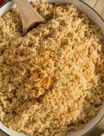 Bowl of Texas Roadhouse seasoned rice with golden-brown color and fresh parsley garnish