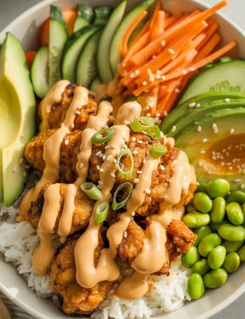 Bang Bang Chicken Bowl with crispy chicken, creamy sauce, rice and fresh vegetables in white bowl