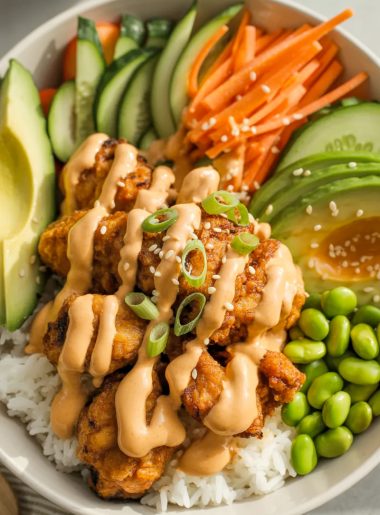 Bang Bang Chicken Bowl with crispy chicken, creamy sauce, rice and fresh vegetables in white bowl