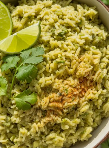 Vibrant green Mexican rice in white bowl garnished with fresh cilantro and lime wedges