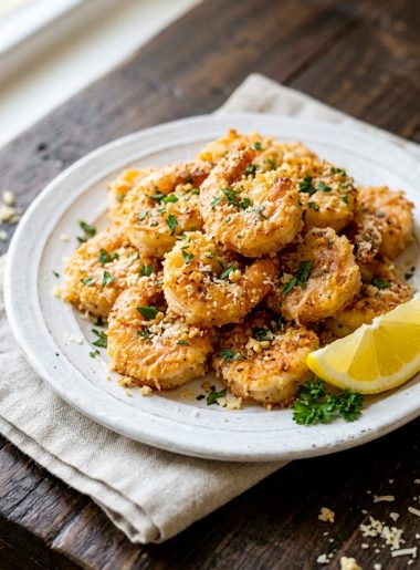 Crispy air fryer garlic parmesan shrimp on a white plate garnished with fresh parsley
