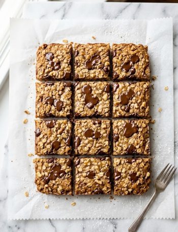 Close-up of sliced banana bread oatmeal bars with chocolate chips on a white marble surface