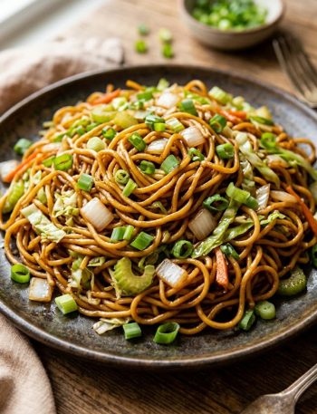 A dark plate piled high with saucy Panda Express copycat chow mein noodles tossed with celery, cabbage, onion and green onions