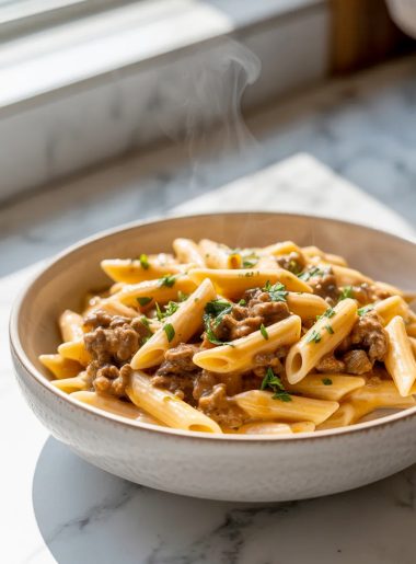 A bowl of quick creamy beef pasta topped with ground beef, creamy cheese sauce and fresh parsley