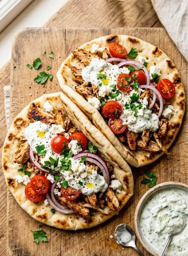Slow cooker chicken gyros with homemade tzatziki sauce served on warm pita bread with fresh toppings