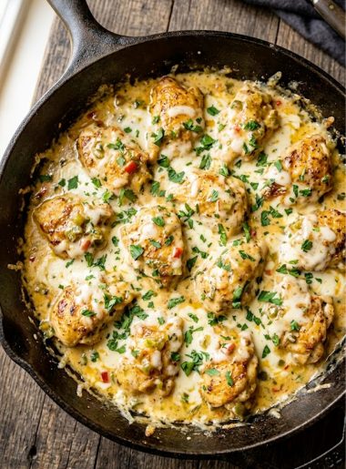Golden seared chicken pieces smothered in a rich creamy queso sauce with green chiles and melted Monterey Jack cheese in a dark skillet